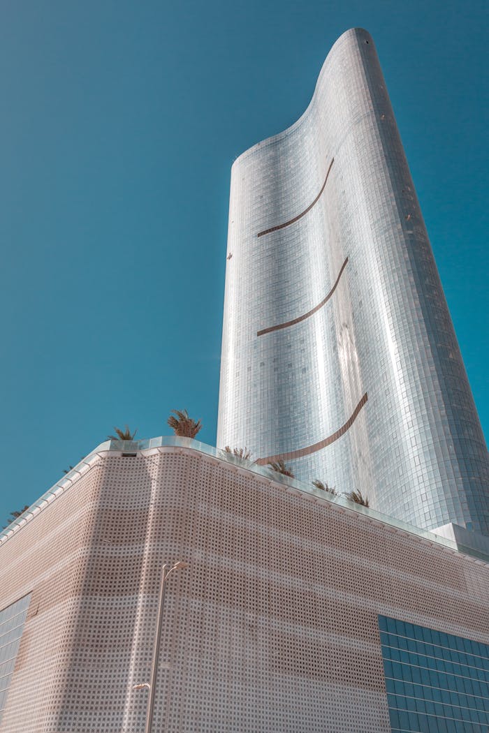 Futuristic skyscraper with unique architecture under a vibrant blue sky, showcasing modern urban design.