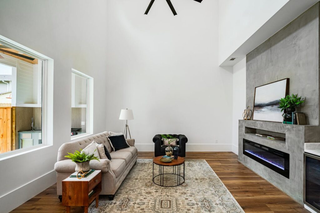 Elegant modern living room interior with high ceiling and natural light.